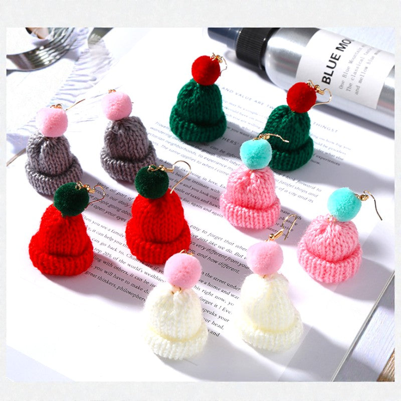 Colorful knit hat keychains with pom-pom balls on a magazine page.