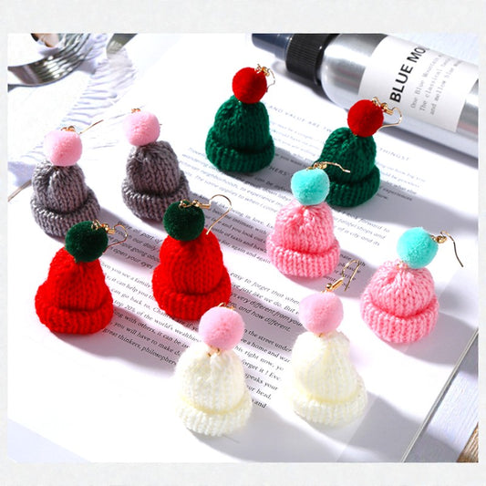 Colorful knit hat keychains with pom-pom balls on a magazine page.